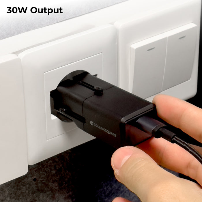Pocket Travel Charger - US/EU/UK/AU plugs - 30W - 1 Port - Compact black 30W travel charger plugged into a white wall socket with attached USB-C cable. - Rolling Square