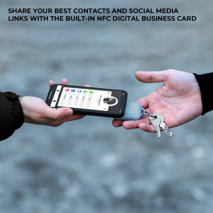 TAU® 2 - Emergency keyring power bank - Mercury Black - Compact charcoal black keyring power bank attached to keys next to smartphone displaying NFC digital business card interface. - Rolling Square