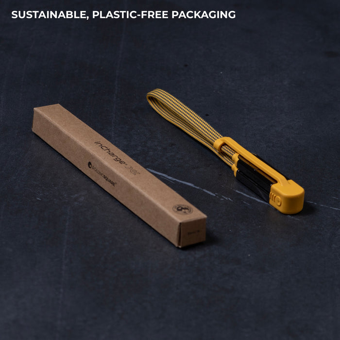 inCharge® XL 30cm / 1ft - 100W, 6in1 travel cable - Urban Black - Yellow flat travel charging cable with USB-C, USB-A, Lightning, and Micro-USB connectors next to slim brown cardboard box. - Rolling Square