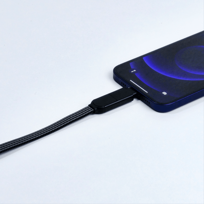 inCharge® X Max - 100W, 6in1 long cable - Lava Black - Black braided 6-in-1 charging cable connected to a modern smartphone with a dark screen and blue glow. - Rolling Square